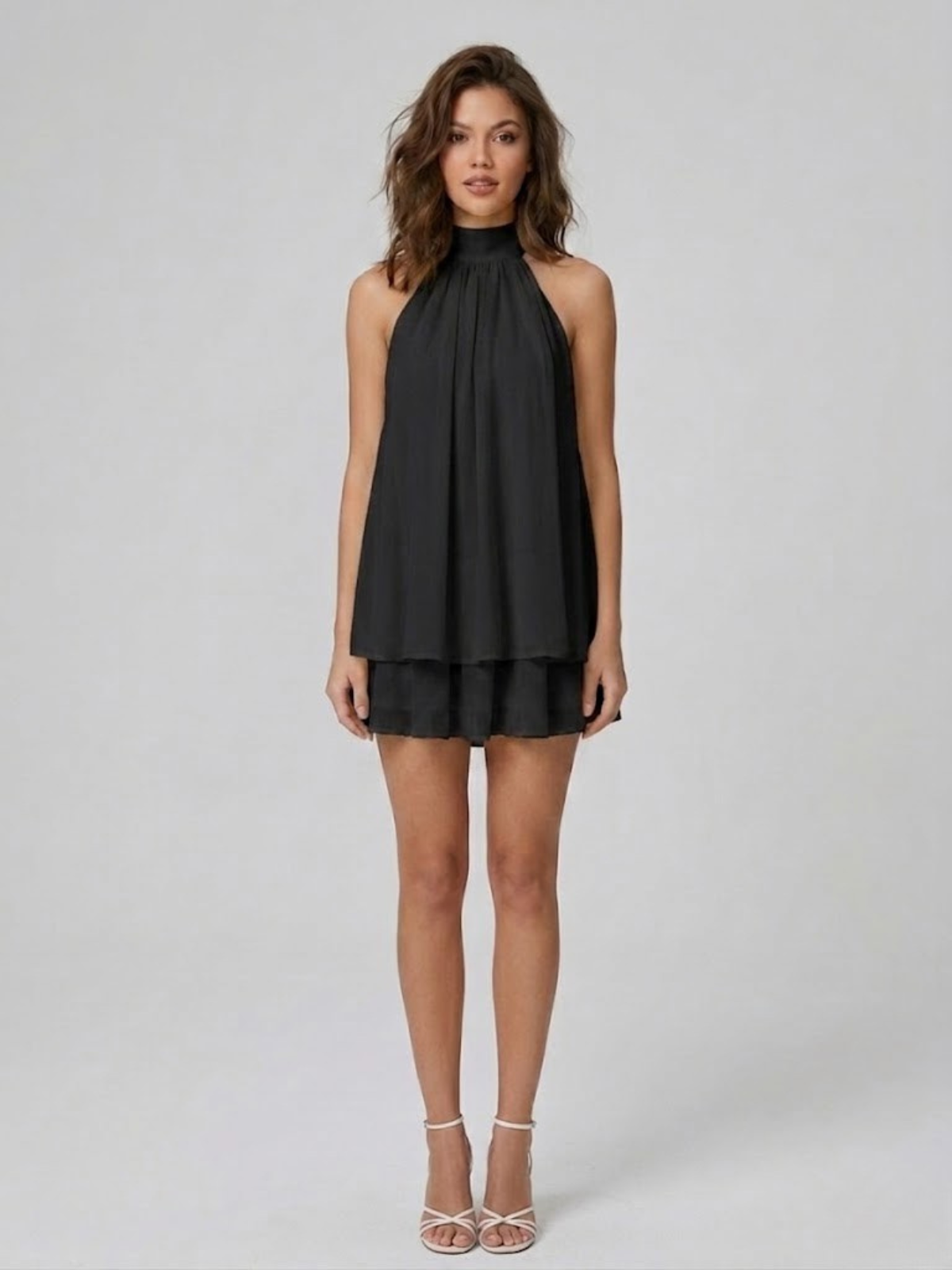 Robe courte noire, col montant halter, dos nu et volants étagés.