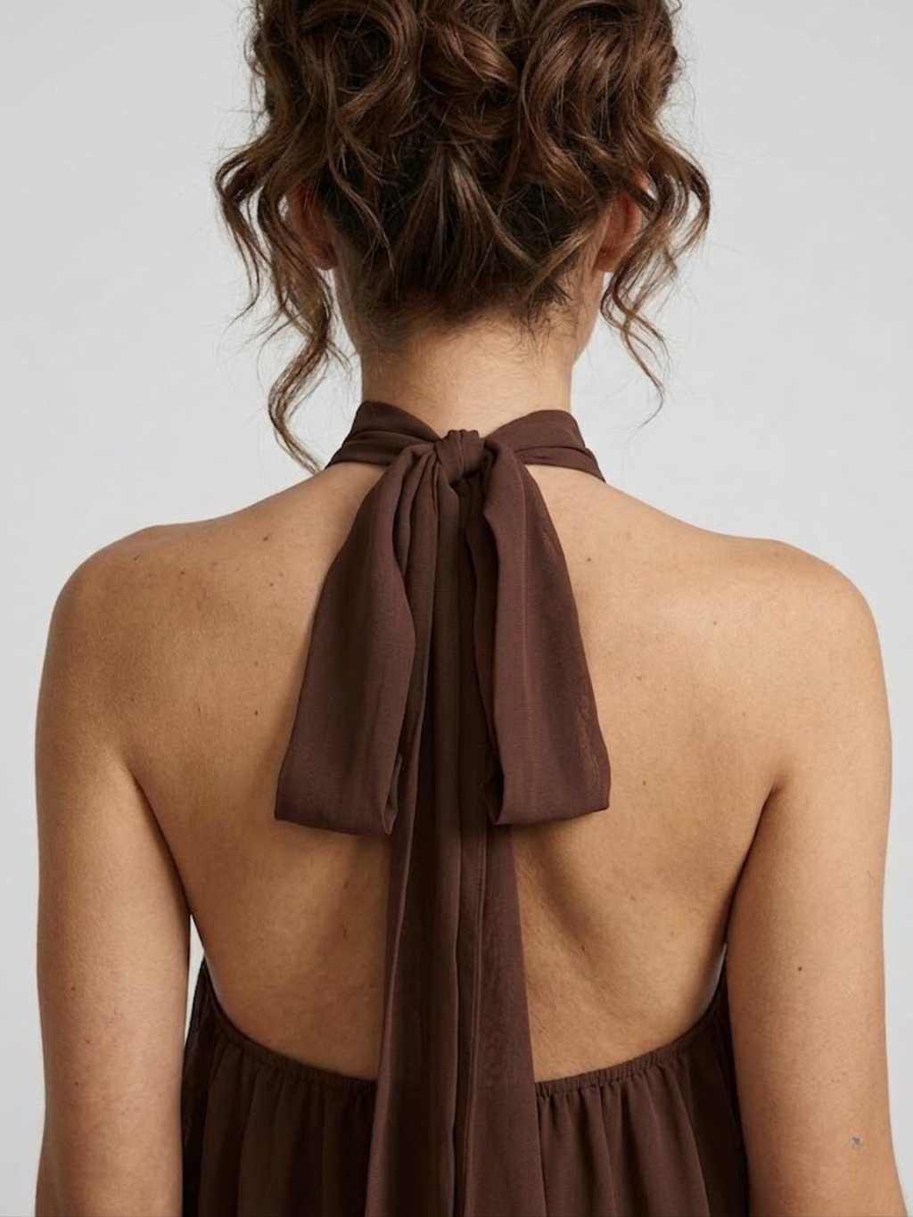 Robe courte, col licou montant, dos nu, jupe à volants étagés.