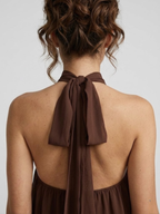 Robe courte, col licou montant, dos nu, jupe à volants étagés.