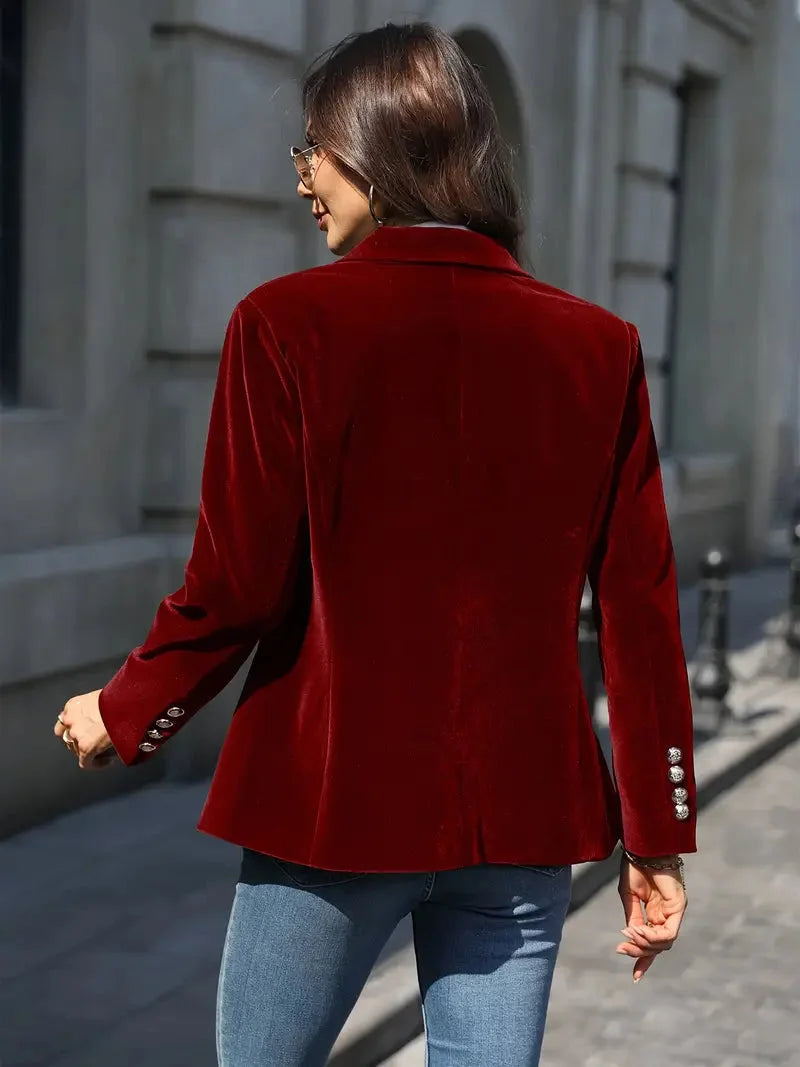 Blazer ajusté en velours rouge pour femme, avec boutons décoratifs modernes et coupe cintrée.