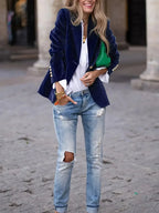 Blazer ajusté en velours bleu marine pour femme, avec boutons décoratifs modernes et coupe élégante.