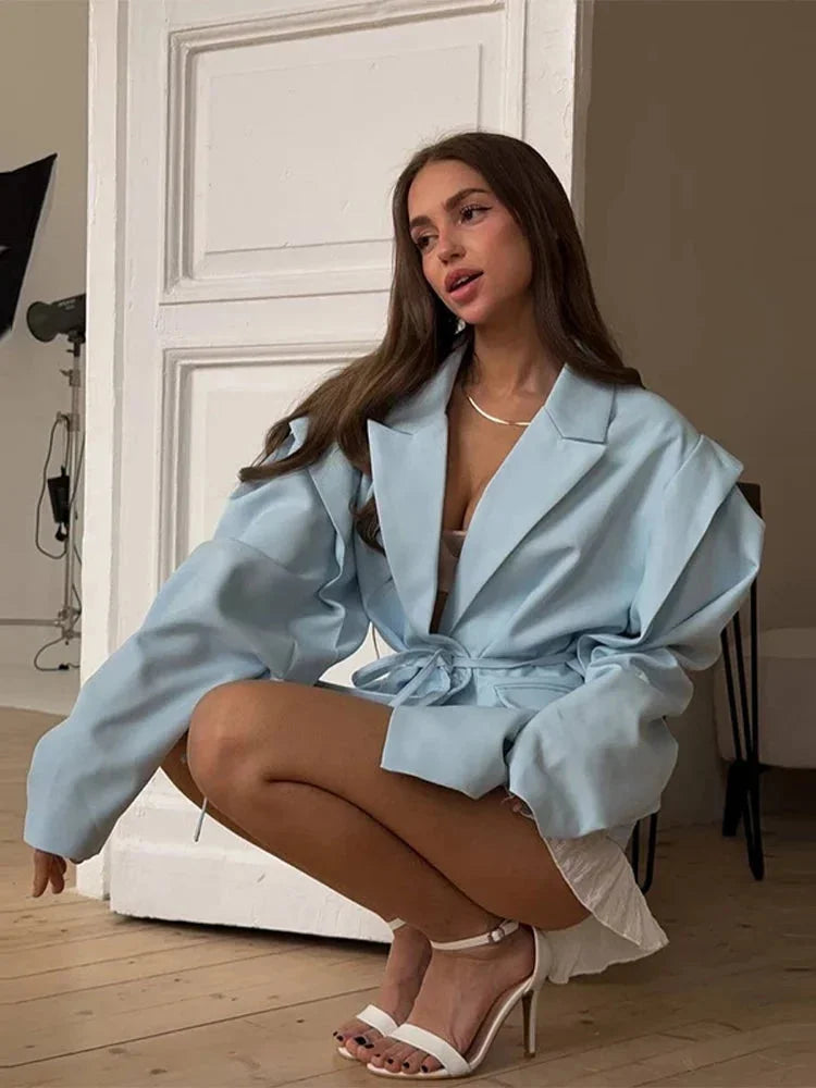 Blazer femme rose à laçage, avec épaulettes et tissu léger pour un style moderne.