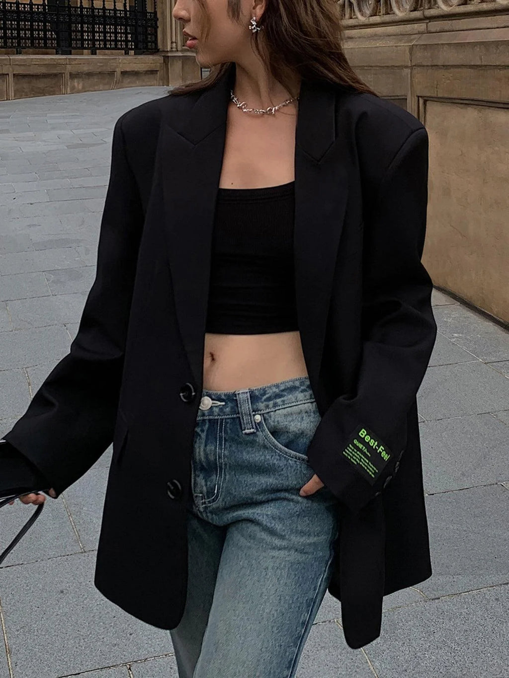 Blazer femme oversize en tissu léger, avec boutons décoratifs et col classique, disponible en plusieurs couleurs douces.