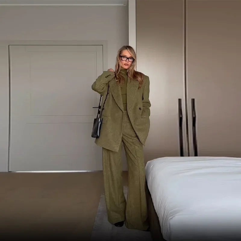 Ensemble blazer vert pour femme avec épaulettes, accompagné d'un pantalon à jambes droites en tissu doux.