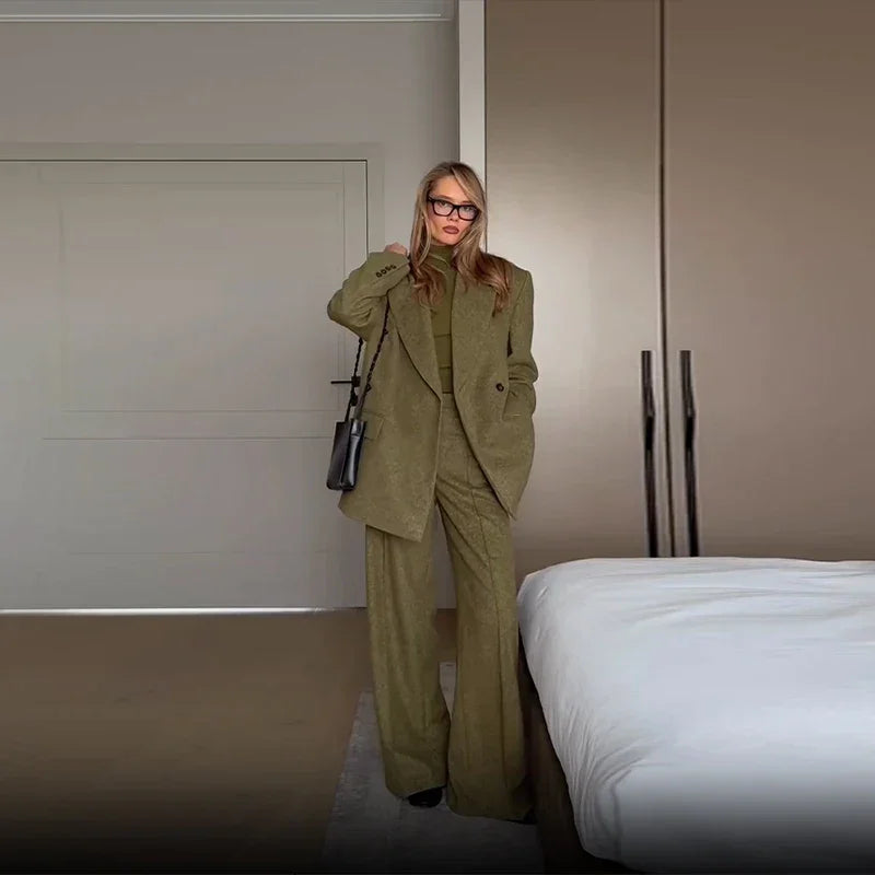 Ensemble blazer vert pour femme avec épaulettes, associé à un pantalon à jambes droites en tissu doux.