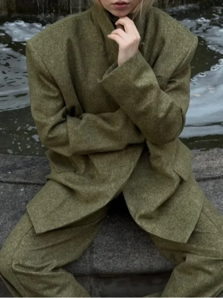 Ensemble blazer vert avec épaulettes et pantalon à jambes droites, en tissu léger.