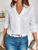 Blouse femme blanche à col V, manches longues, en tissu doux et respirant, au design intemporel.