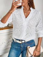 Blouse femme blanche à col V et manches longues, en coton léger avec un motif délicat.