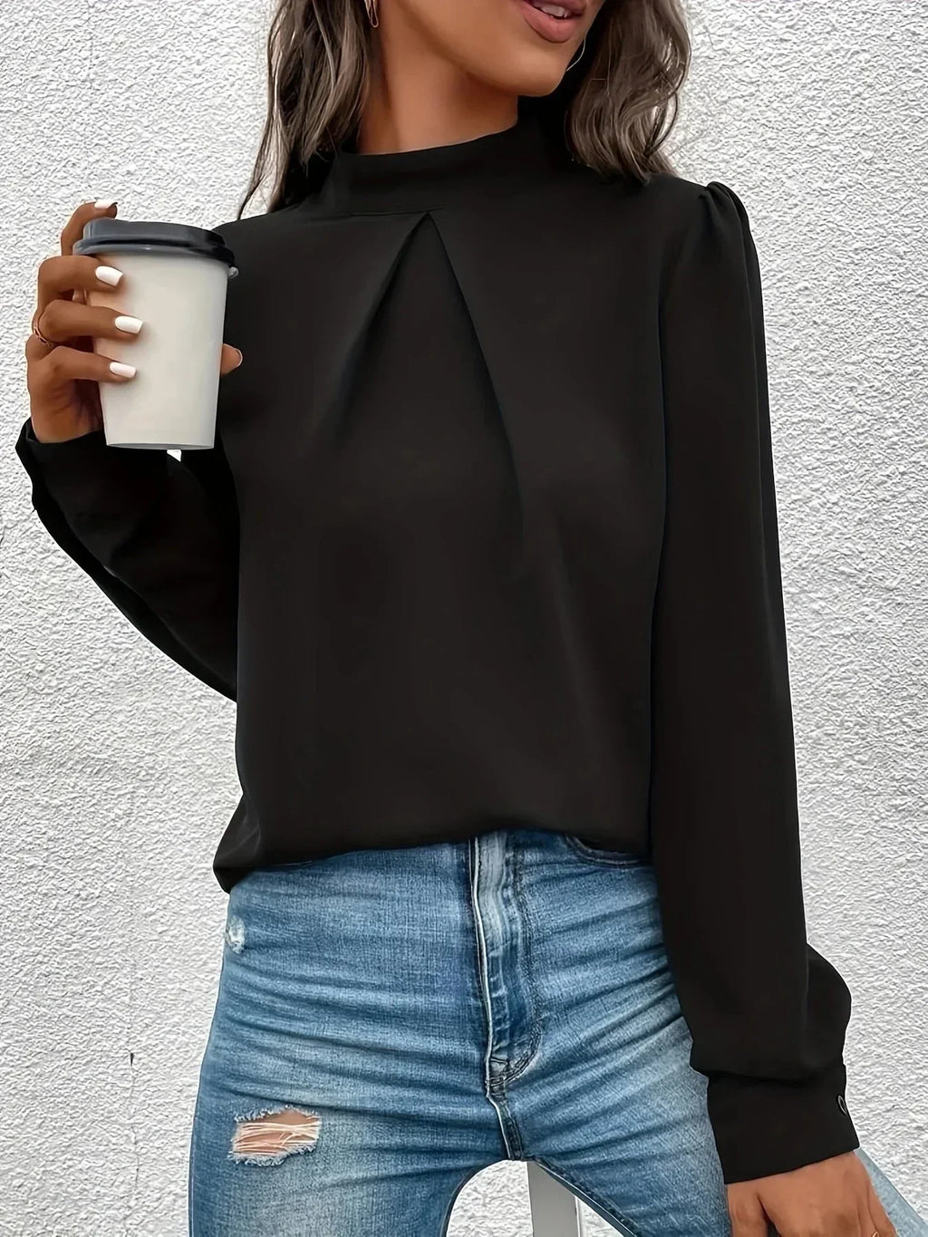 Haut noir à manches longues pour femme, en tissu doux et respirant, avec un design élégant et un fin ajustement.