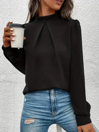 Haut noir à manches longues pour femme, en tissu doux et respirant, avec un design élégant et un fin ajustement.