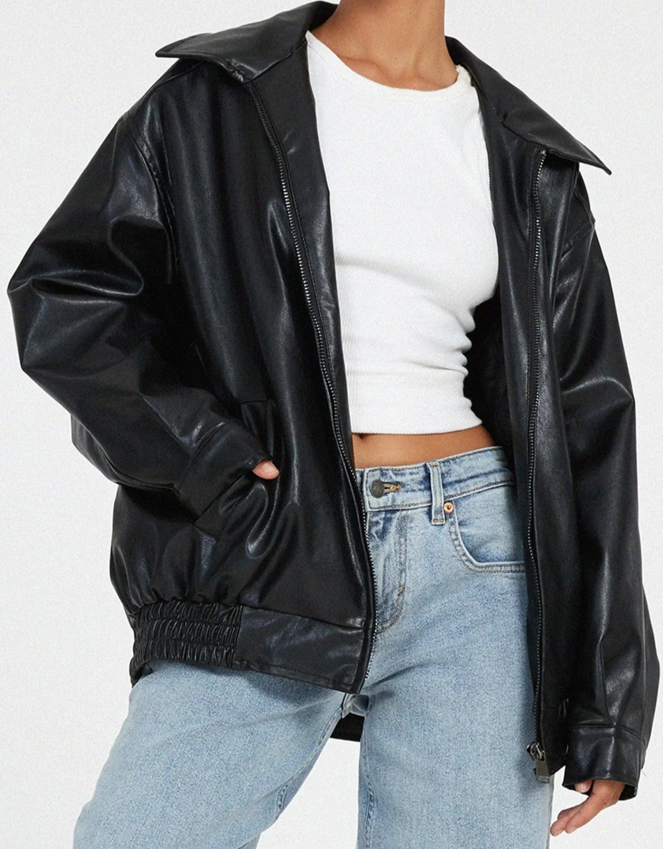 Blouson femme motard en similicuir noir avec zip asymétrique et poches zippées classiques.