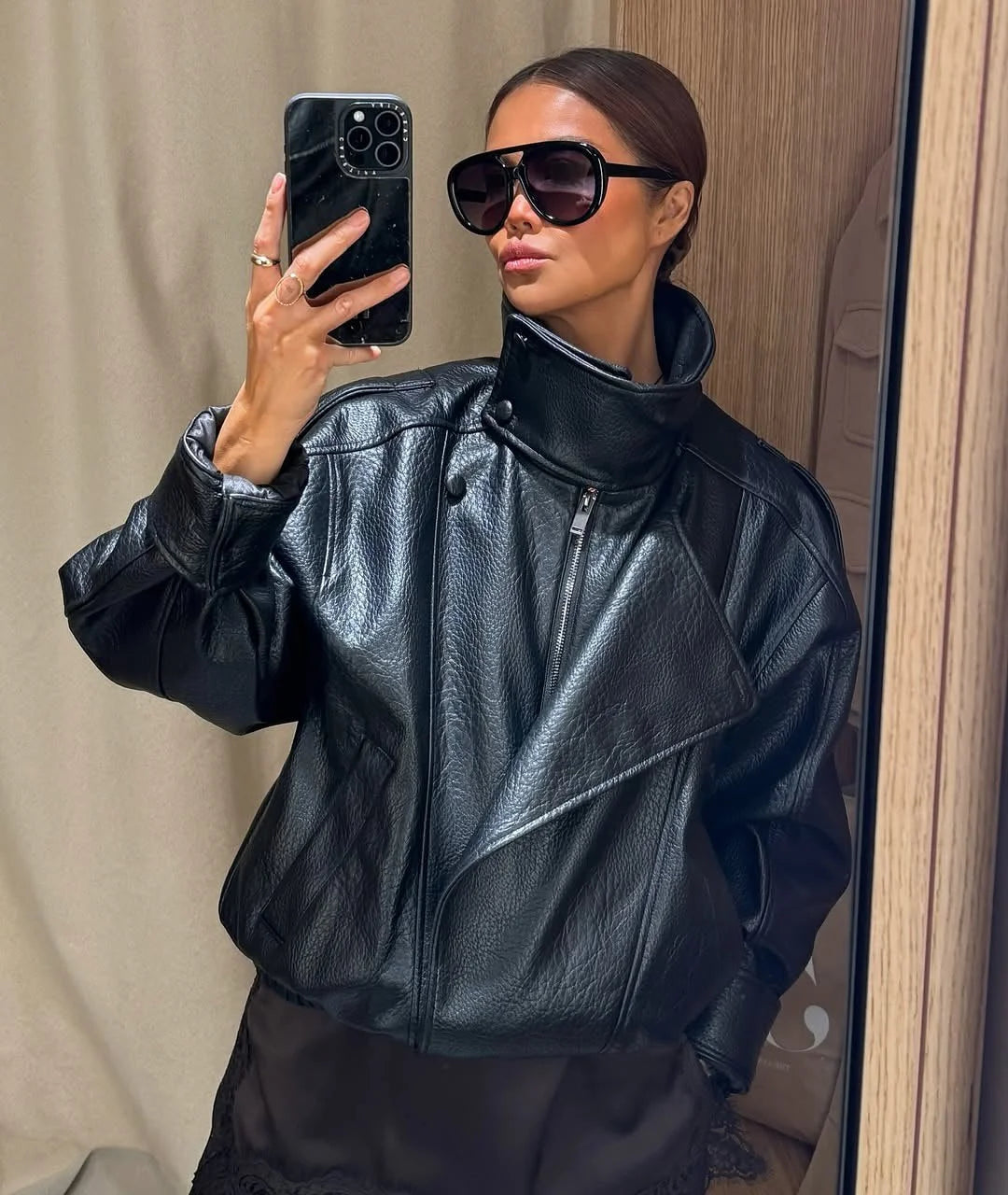 Blouson noir pour femme avec col montant, en tissu léger, design moderne adapté aux saisons intermédiaires.