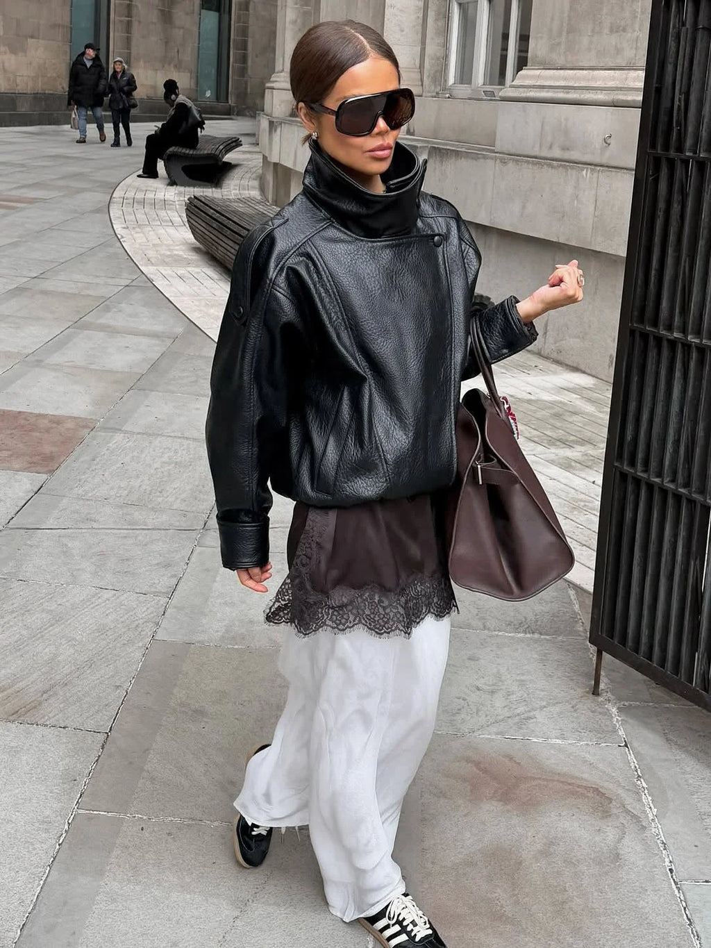 Blouson noir pour femme avec col montant, en tissu doux, adapté aux conditions météorologiques changeantes.