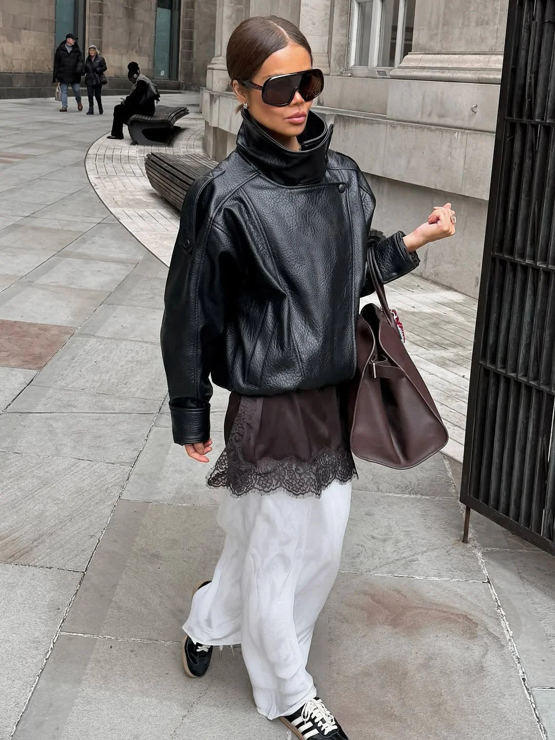 Blouson noir pour femme avec col montant, en tissu doux, adapté aux conditions météorologiques changeantes.