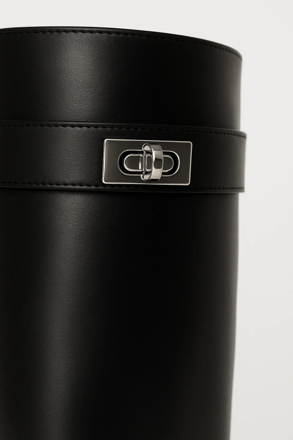 Bottes hautes noires en simili cuir avec fermeture décorative pour un style moderne.