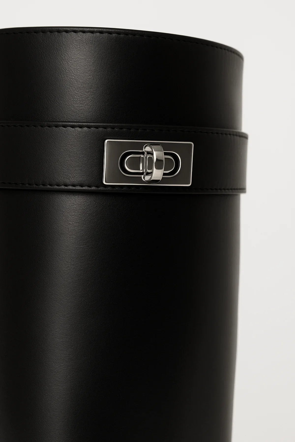 Bottes hautes noires en simili cuir avec fermeture décorative pour un style moderne.