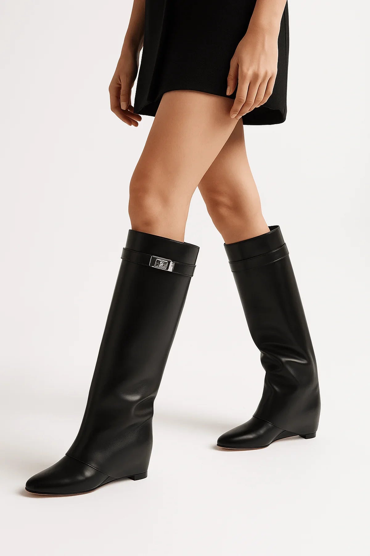 Bottes hautes noires en simili cuir avec fermeture décorative sur le côté.