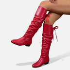 Bottes mi-hautes rouges en cuir souple, avec nœud décoratif et talon bas, idéales pour le quotidien.