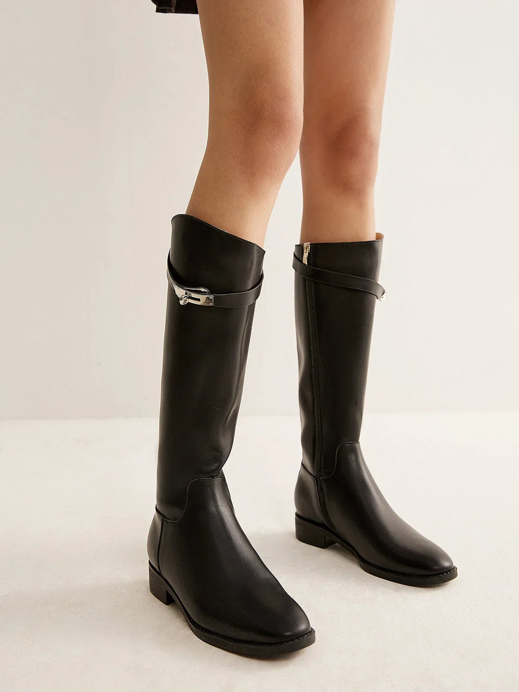 Bottes noires en cuir style équestre avec détail de boucle et design robuste, adaptées pour les cavaliers.