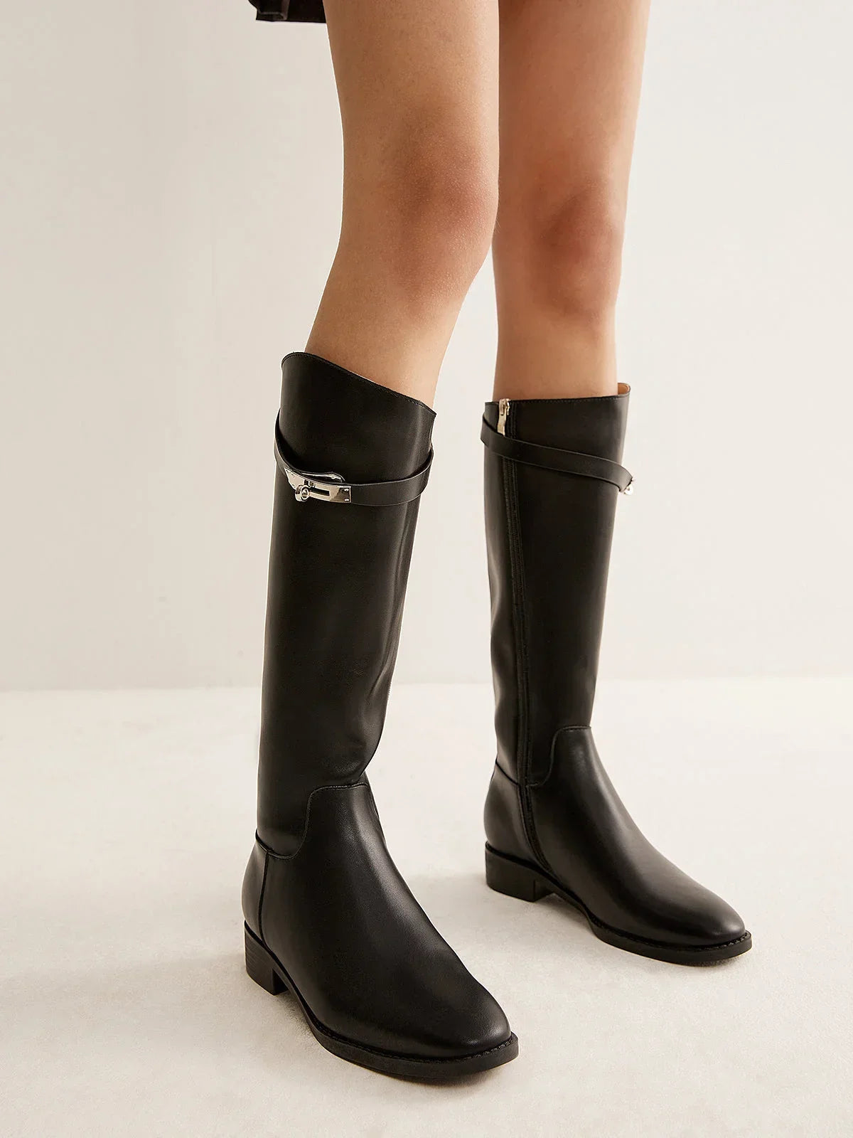 Bottes noires en cuir style équestre avec détail de boucle et design robuste, adaptées pour les cavaliers.