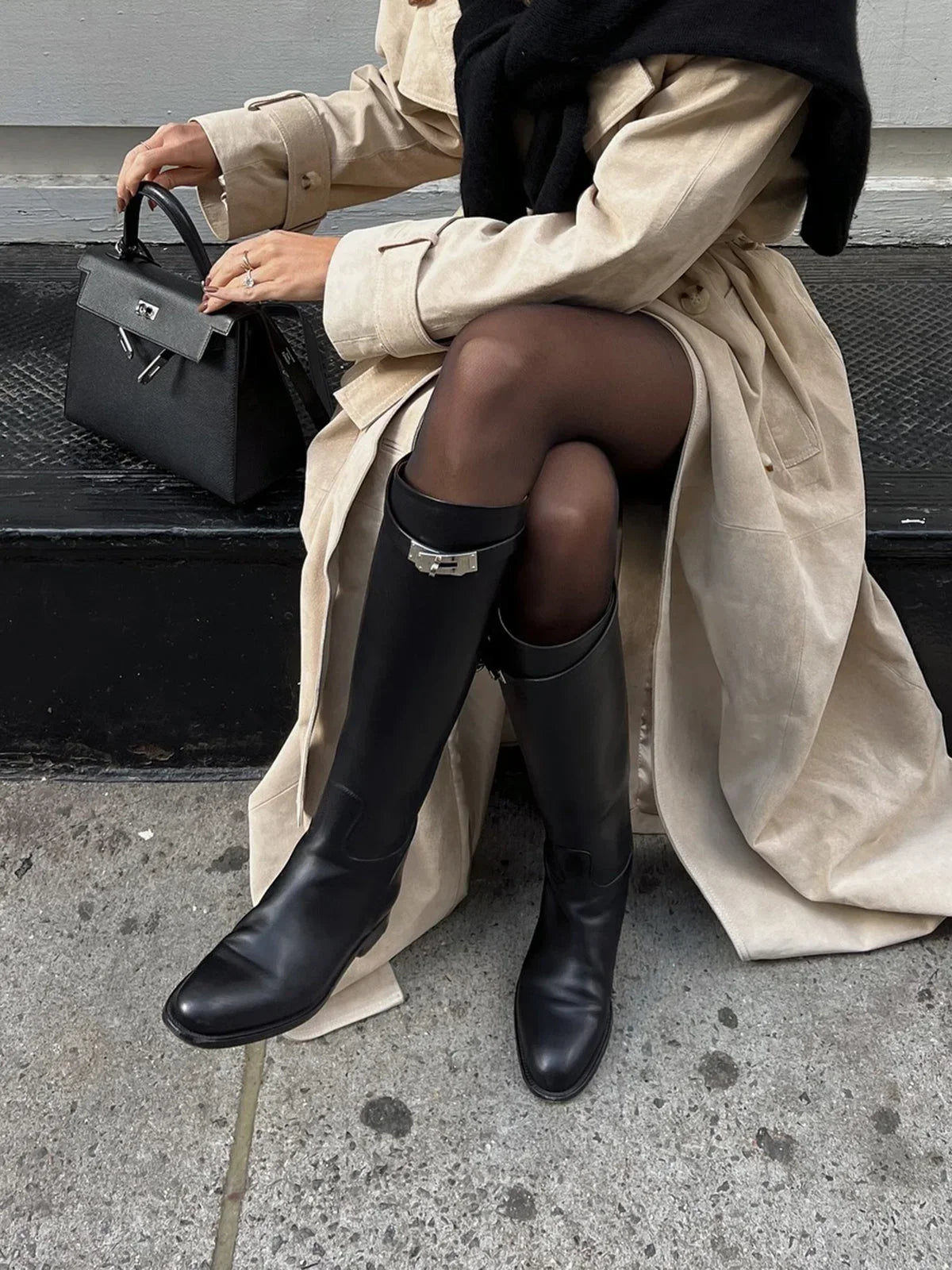 Bottes noires en cuir style équestre avec détail de boucle sur le haut.