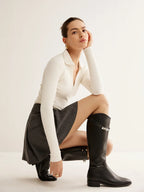 Bottes noires en cuir, style équestre, avec détail de boucle et design classique.