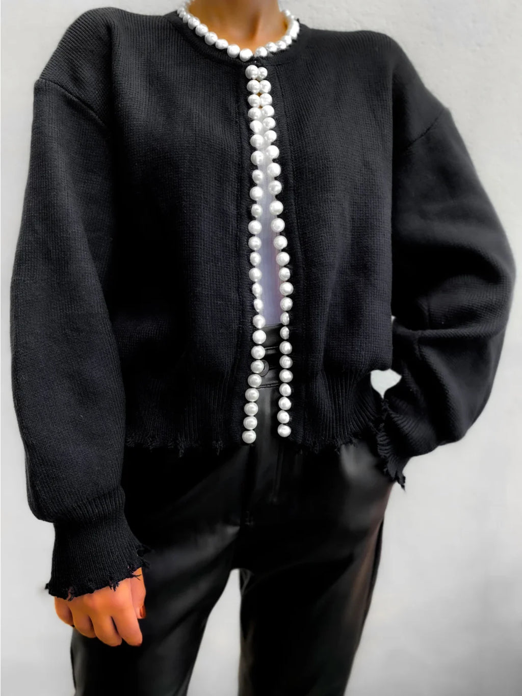 Cardigan femme noir en matière douce, avec détails en perles et coupe classique pour des looks variés.