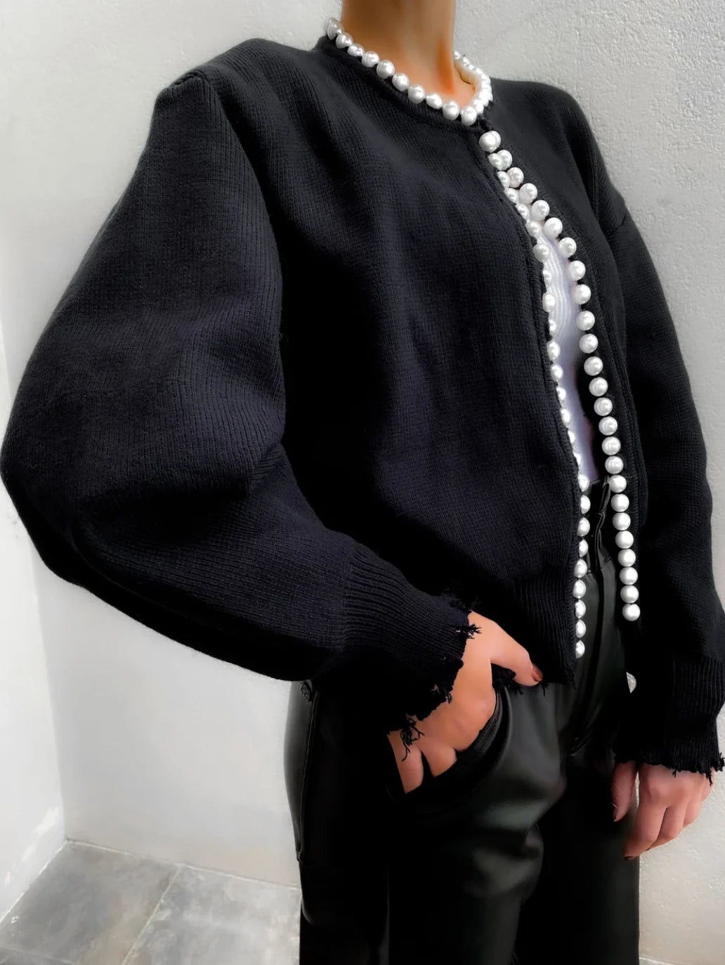 Cardigan femme noir en matière légère avec détails en perles, coupe classique et manches longues.