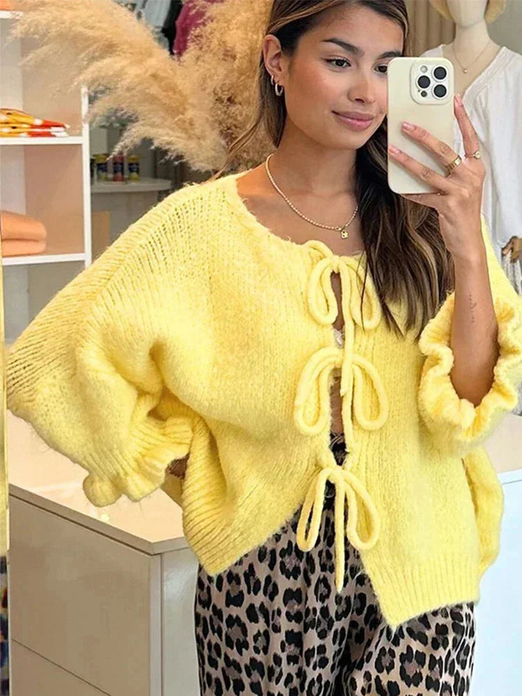 Gelber Cardigan für Damen mit offenen Vorderseiten und dekorativen Knoten, aus weichem, atmungsaktivem Material gefertigt.
