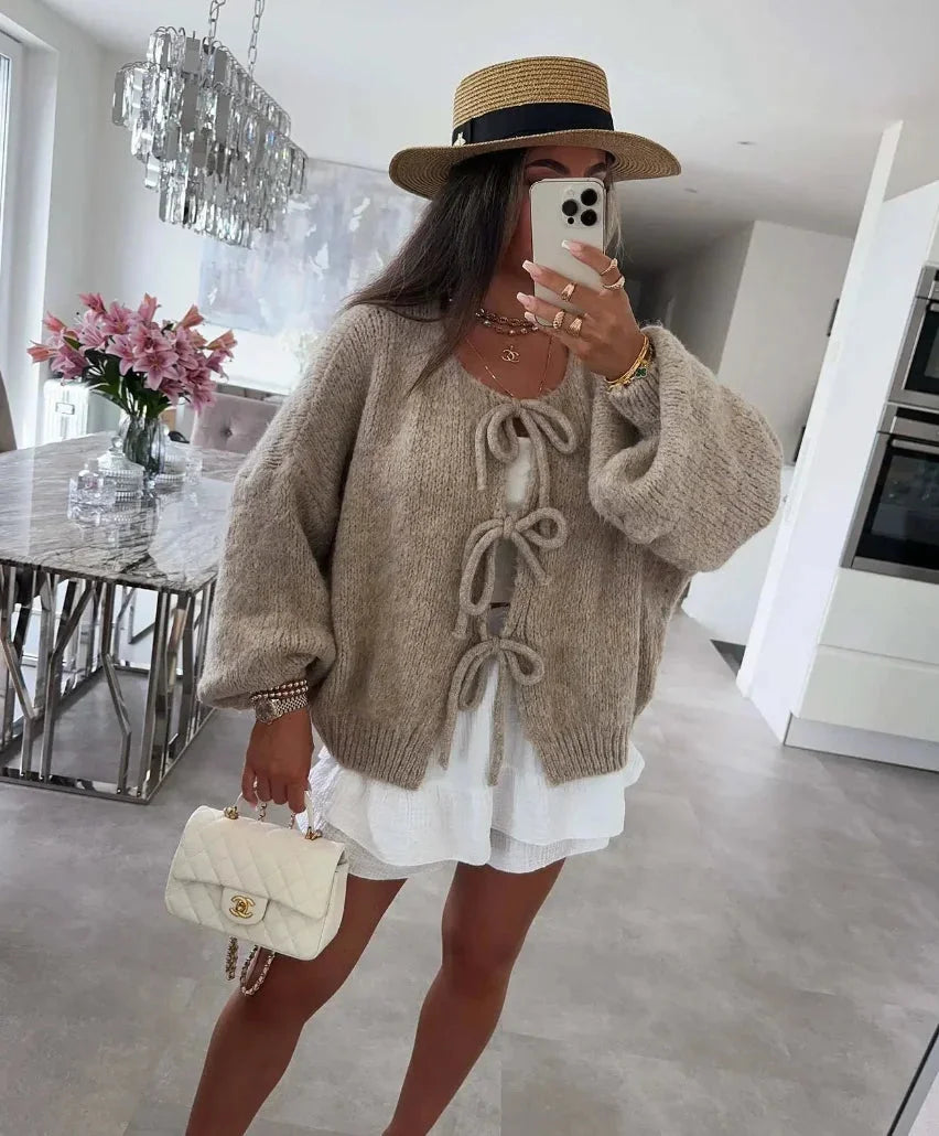 Cardigan femme gris avec manches amples tricotées et design noué, adapté pour des tenues décontractées.