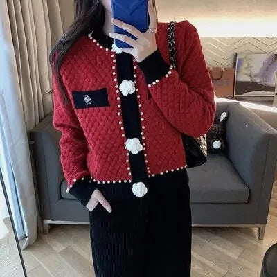 Cardigan blanc en tricot doux avec ornements en perles et poches décoratives.