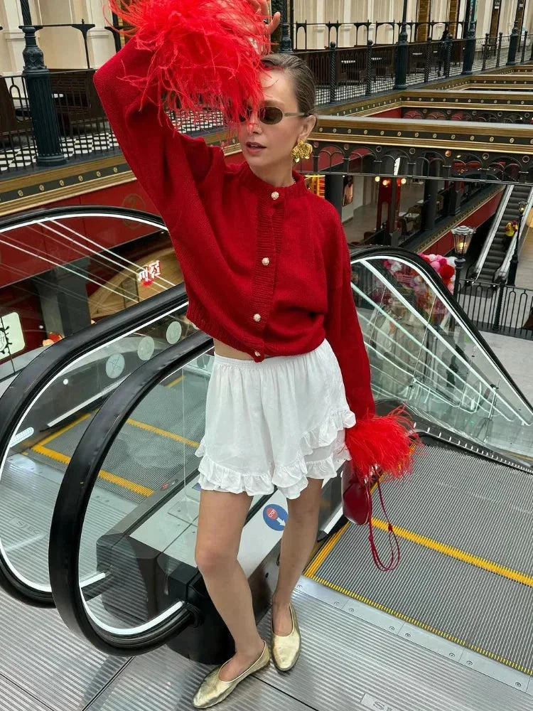 Cardigan femme rouge avec manches plumes et boutons, en tissu doux, pour un confort élégant.