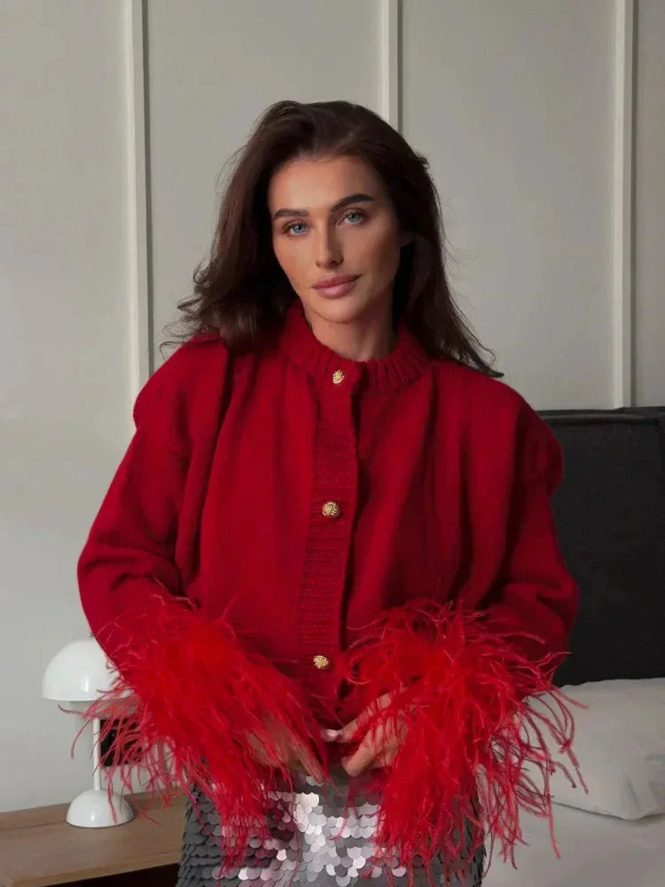 Cardigan femme rouge avec manches plumes et boutons, design élégant et confortable.