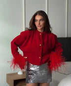 Cardigan femme rouge avec manches en plumes et boutons, en tissu doux, coupe élégante.
