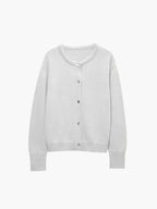 Cardigan femme en tricot blanc, avec fermeture à boutons, adapté pour l'hiver et les styles variés.