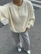 Cardigan femme en tricot blanc, boutonné, coupe confortable, design classique, adapté pour l'hiver.