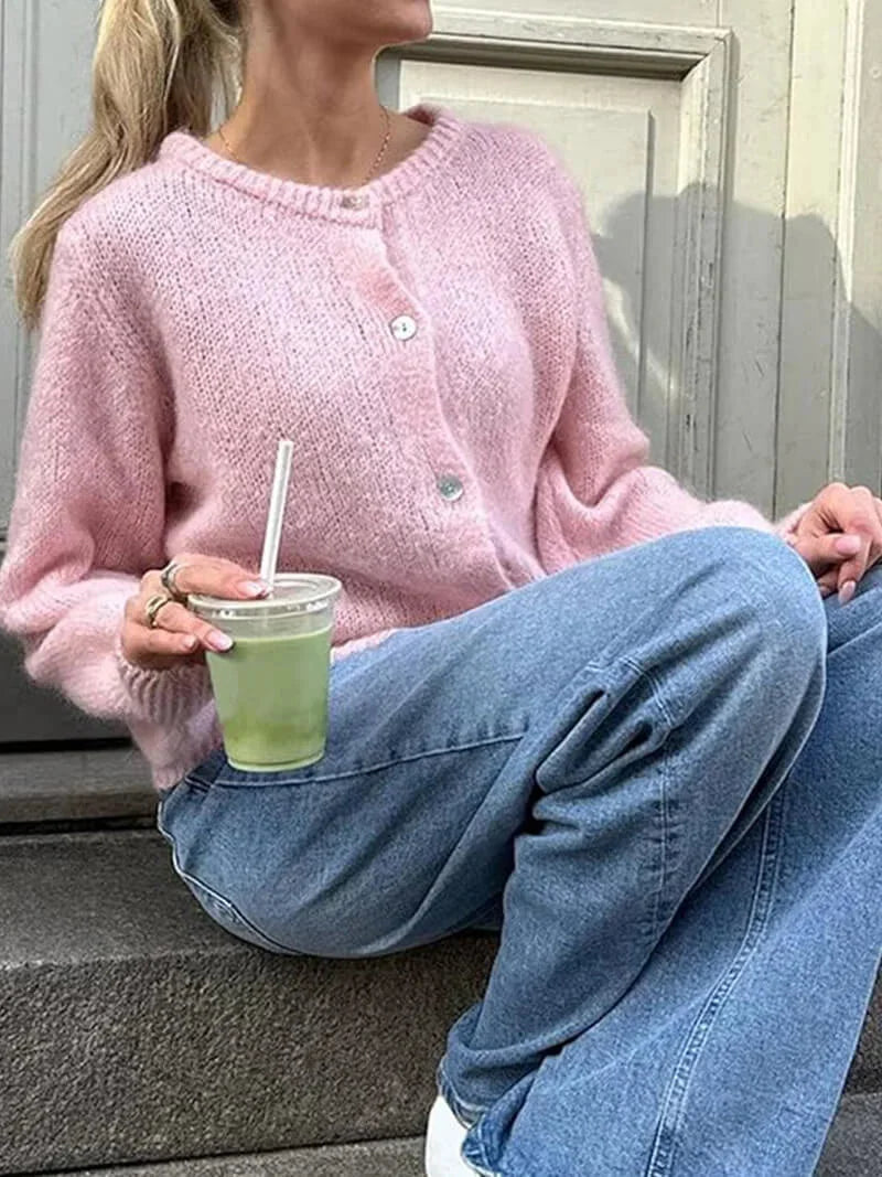 Cardigan en tricot rose pour femme, boutonné, avec un design classique adapté aux journées froides d'hiver.