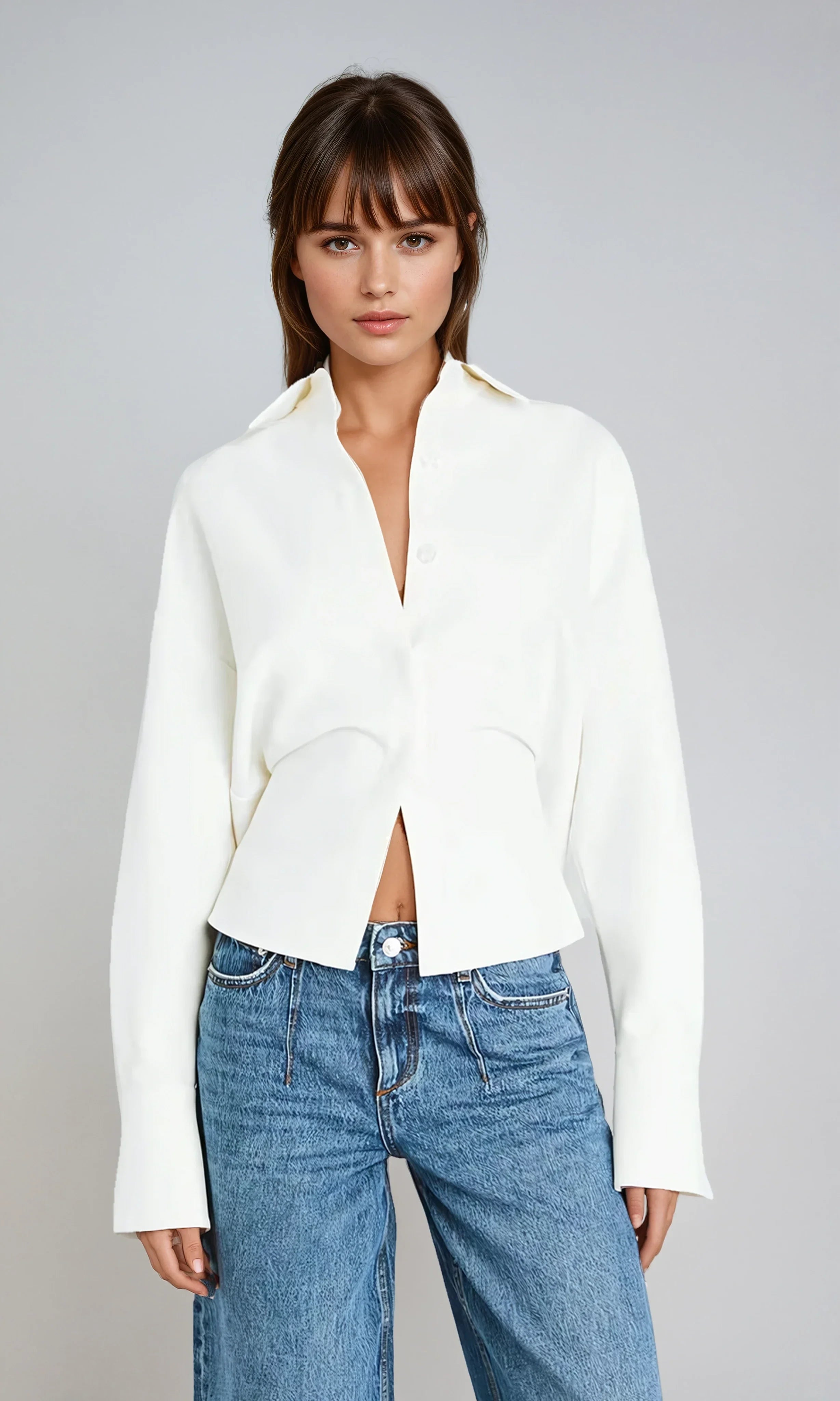 Chemise fluide blanche cassée pour femme, avec boutonnière et coupe ample.