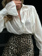 Chemisier femme rose à col classique, manches évasées et tissu léger, design polyvalent.