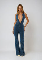 Combinaison en denim bleu marine pour femme, décolleté plongeant et coupe ajustée, parfaite pour des tenues décontractées.