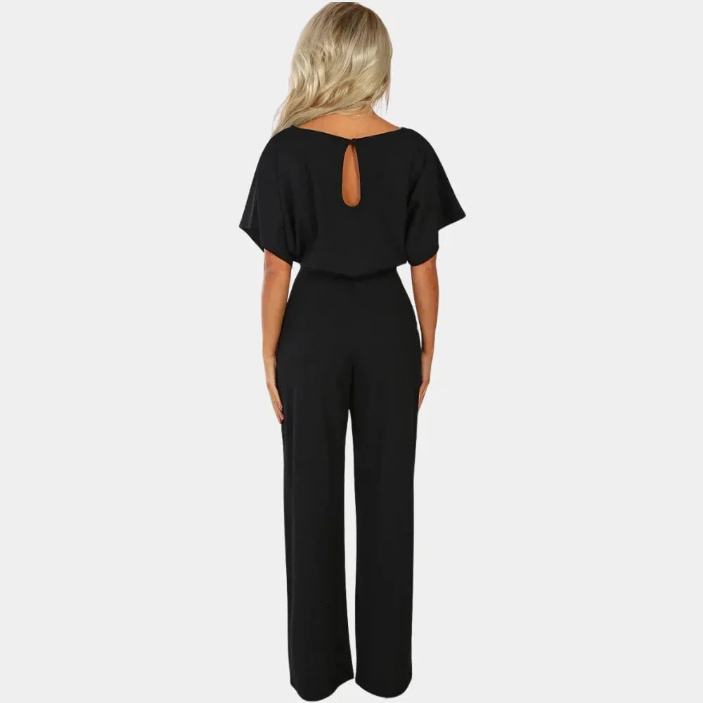 Combinaison femme noire à jambes larges, ceinture et manches kimono en tissu respirant.