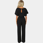 Combinaison femme noire à jambes larges, ceinture et manches kimono en tissu respirant.