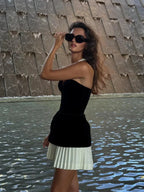 Ensemble bustier noir en tissu satiné avec jupe plissée blanche, sans bretelles, parfait pour une soirée élégante.