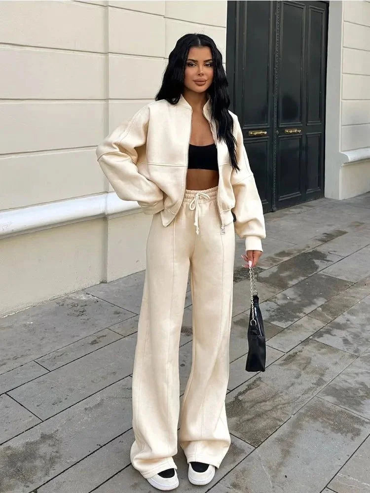 Ensemble de jogging femme gris avec veste ample et poignets élastiques pour un ajustement confortable.