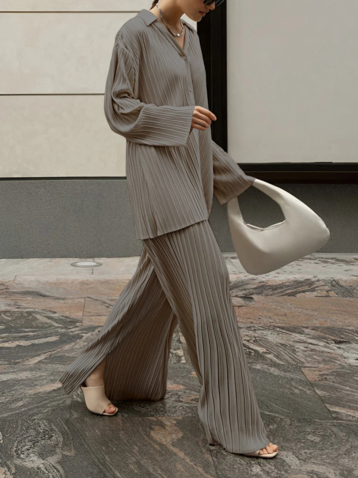 Beige zweiteiliges Damen-Ensemble aus plissiertem Stoff, mit bequemem Schnitt und lässigem Design für vielseitige Anlässe.