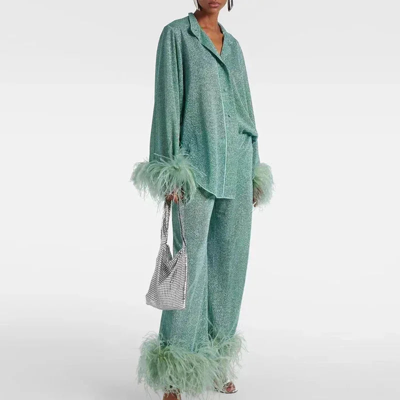 Ensemble femme rouge vin en tissu brillant, avec manches et bas en plumes, adapté pour des occasions spéciales.