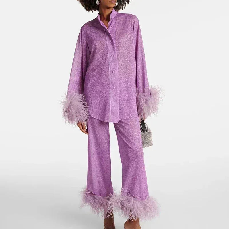 Ensemble femme vert clair, tissu brillant, manches bouffantes et détails en plumes au bas.