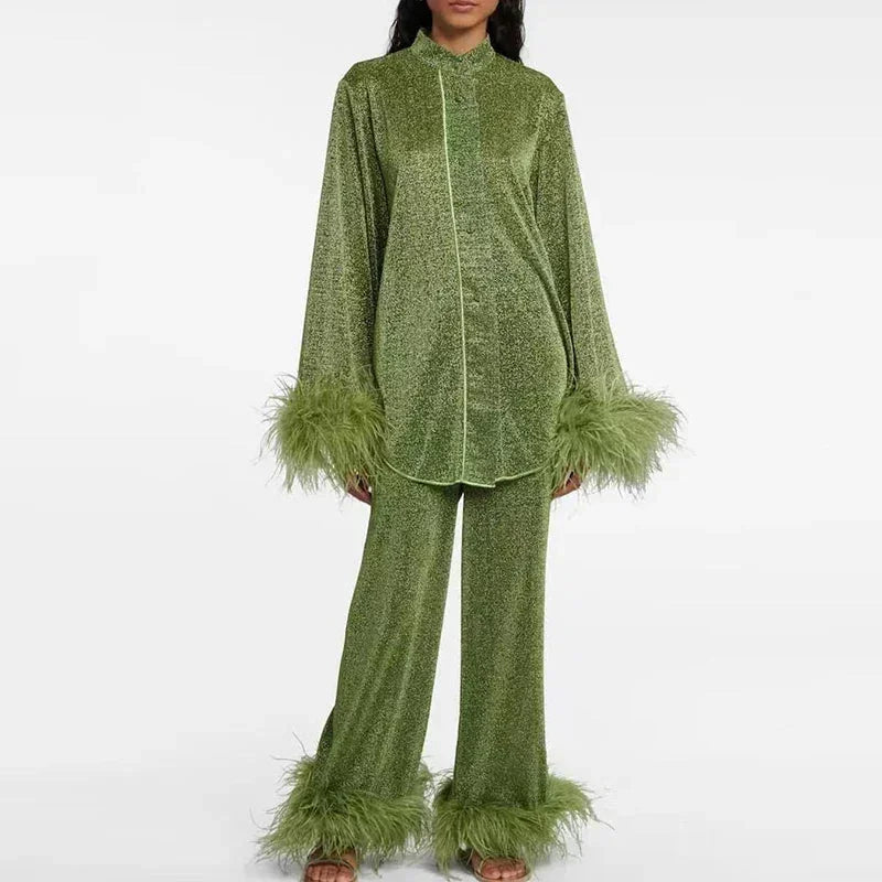 Ensemble femme vert clair en tissu brillant, avec manches en plumes et bas assorti.