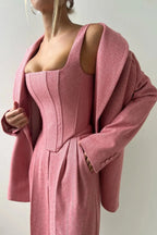 Ensemble femme trois pièces en tissu élastique, comprenant un haut ajusté, un rock et un blazer noir au design soigné.