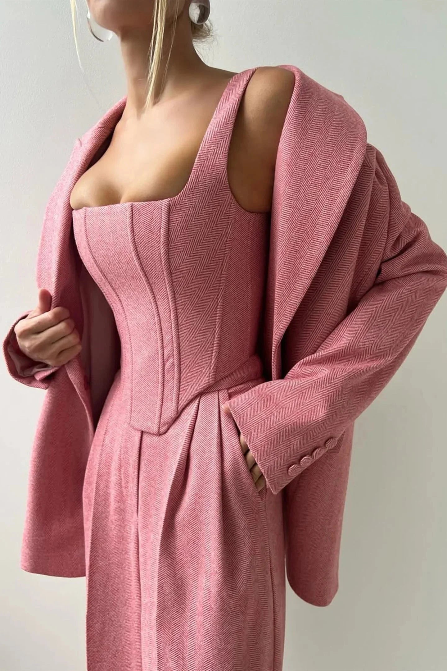 Ensemble femme trois pièces en tissu élastique, comprenant un haut ajusté, un rock et un blazer noir au design soigné.